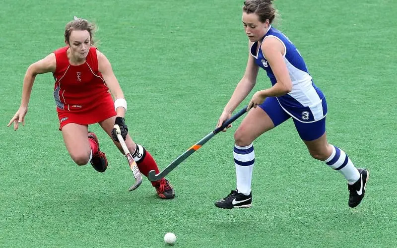 Two girls playing hockey